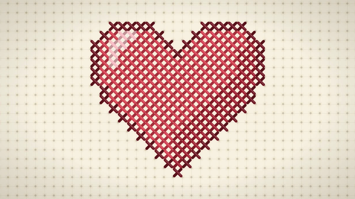Stitched red cross stitch heart with a pale pink highlight and darker shading on cream Aida