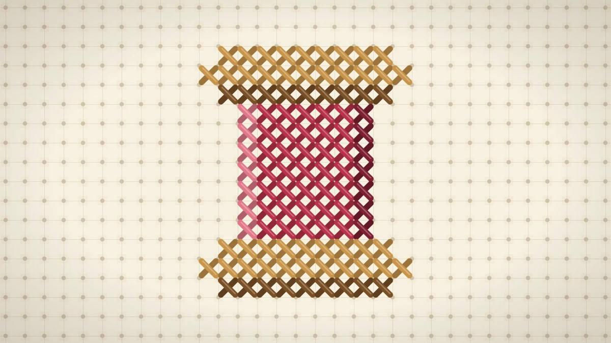 Small cross stitched spool of cherry red thread with honey brown ends on cream Aida fabric