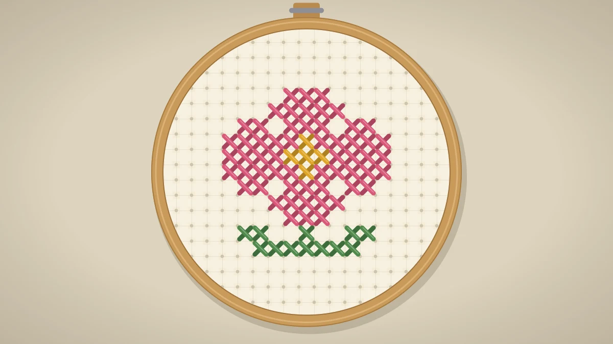 Small pink cross stitch blossom with a yellow center and green leaves in a hoop