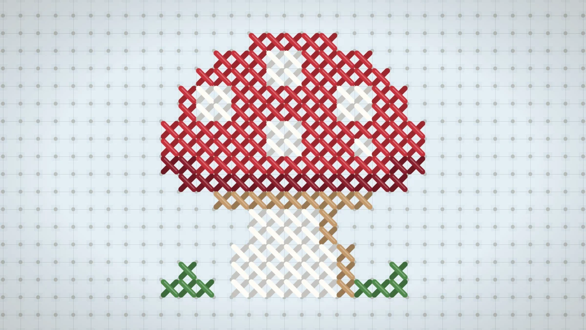 Mini cross stitch mushroom with a red cap and white spots stitched on sky blue Aida